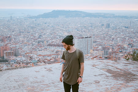 man standing on concrete road beside buildings thumbnail