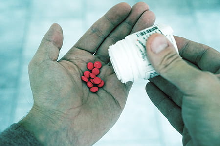 man holding white plastic tablet bottles thumbnail
