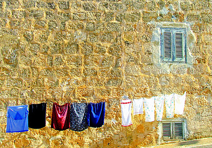 assorted clothes hanging on gray string during daytime photo thumbnail
