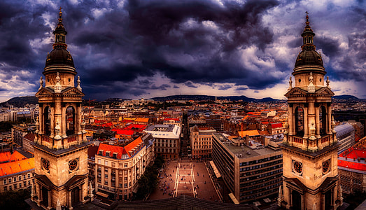 aerial photography of cathedral beside buildings at cloudy skies thumbnail