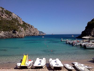 boats beside body of water and rock formations thumbnail
