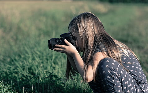 Girl Holding Dslr Camera on Green Grass Field thumbnail