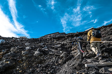 two person climbing rocky mountain during daytime thumbnail