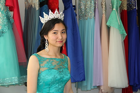 smiling woman standing beside dresses thumbnail