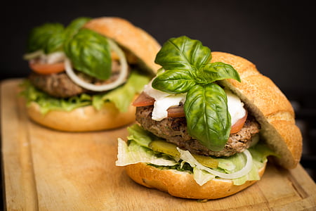 hamburger with tomato and lettuce on brown board thumbnail