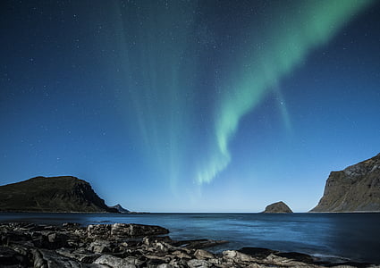 low-angle photography of gray mountain beside body of water thumbnail