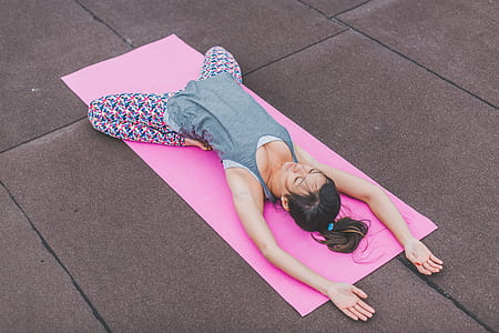 woman wearing gray sleeveless top and multicolored leggings doing yoga thumbnail
