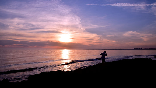 person walking on seashore near seawave thumbnail