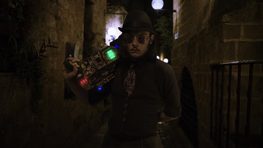man holding brown weapon standing near black metal frame thumbnail