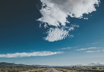 gray asphalt road under blue and white cloudy sky during daytime thumbnail