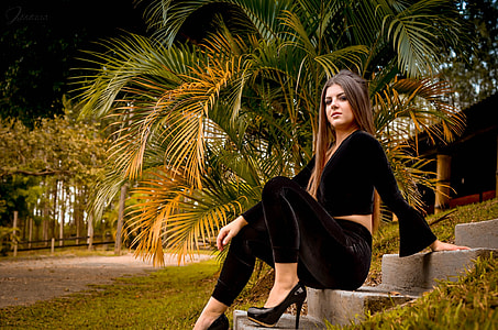 woman wearing black long sleeve shirt with black fitted pants sitting on gray stair thumbnail