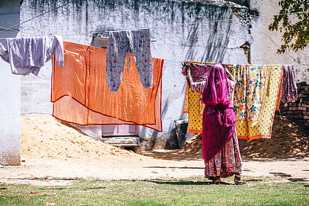 woman hanging clothes near tree thumbnail