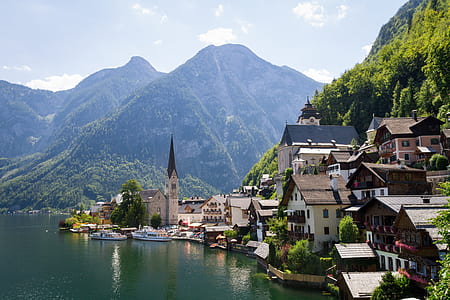 houses on foot of mountains near body of water at daytime thumbnail