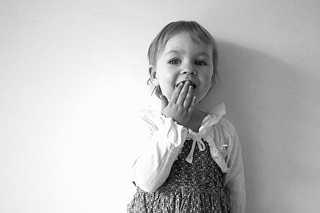 grayscale photography of a girl in long-sleeved dress white covering her mouth thumbnail