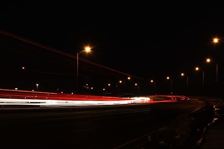time lapse photo of vehicle passing on road at night time thumbnail