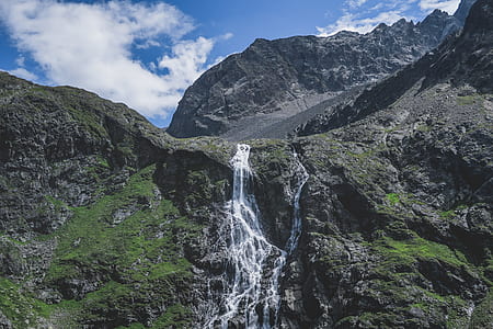 mountain with waterfall under blue sky thumbnail