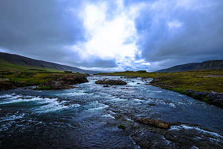 river and green mountain under white cloudy sky thumbnail