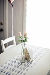 pink roses in clear glass vase on brown wooden dining table thumbnail