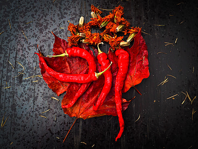 red jalapenos on dried leaves thumbnail