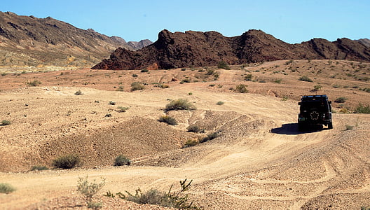 black SUV on desert in distant of mountains thumbnail