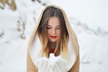 woman holding snow during daytime thumbnail