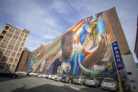 assorted vehicles parking beside wall with graffiti during daytime thumbnail