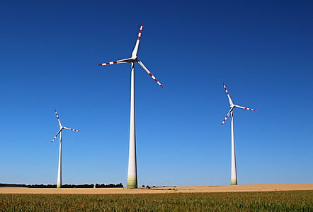 worm's-eye view of windmills under blue sky thumbnail