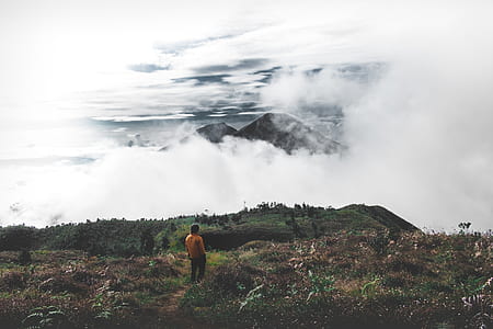 person standing on mountain cover by clouds thumbnail