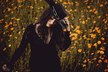 woman in black scoop-neck long-sleeved dress standing near petaled flower fields thumbnail
