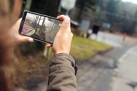 person capturing a photo of road using black smartphone thumbnail