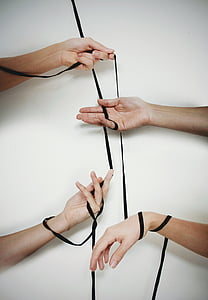 four person's hand holding black cord thumbnail