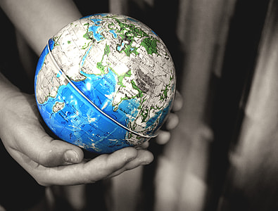 selective color photography of person holding desk globe thumbnail