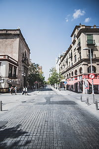 gray concrete road between buildings thumbnail
