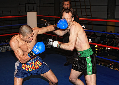 man in blue trunks punched face of man in black trunks inside boxing ring thumbnail