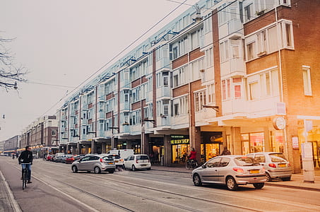 cars near white concrete building thumbnail