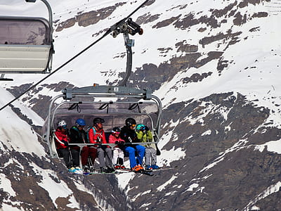 six person riding cable car near snow covered mountains during daytime thumbnail