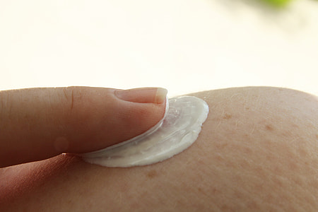 close view of person applying cream with one finger on skin thumbnail
