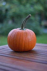 selective focus photo of orange pumpkin on brown wooden table thumbnail