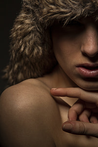 woman touching shoulder with index finger and brown wearing fur hat thumbnail