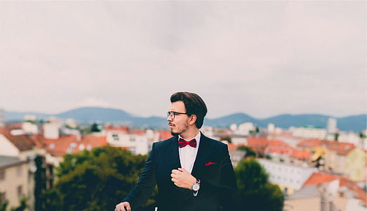 selective focus photography of man wearing black suit jacket thumbnail