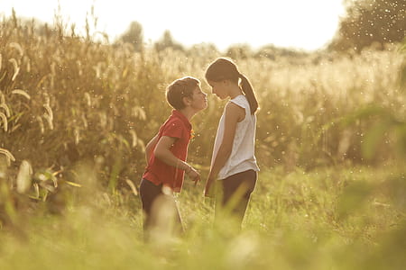 girl and boy kissing infront of grass fields thumbnail