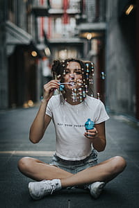 woman blowing bubble while sitting on floor thumbnail