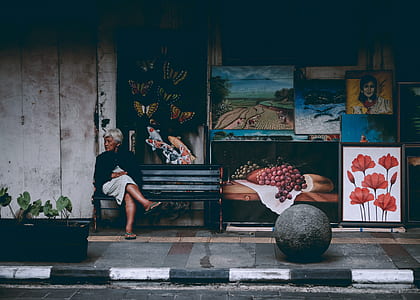 woman sitting on bench beside street thumbnail