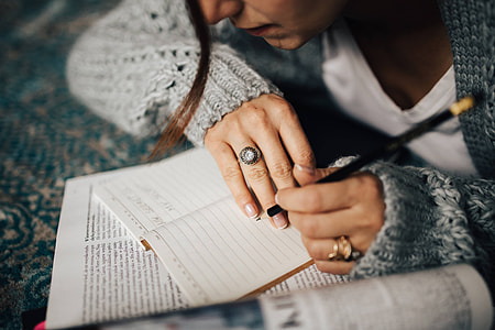 Woman in a grey sweater taking notes in an organizer thumbnail