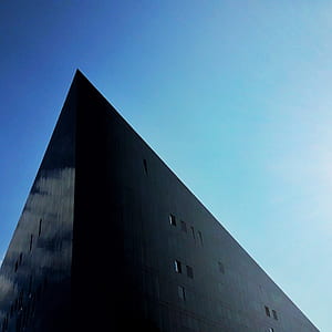 low angle photo of concrete high-rise building under blue sky at daytime thumbnail