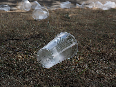 close-up photography of clear plastic cup on green grass thumbnail