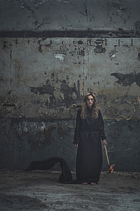 woman holding torch white standing beside gray concrete wall looking straight thumbnail
