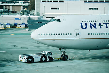 close up photograph of white airplane beside white vehicle during daytime thumbnail