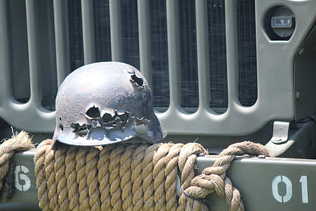 black metal hat near green vehicle grille thumbnail