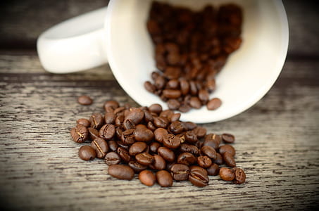 white ceramic teacup pouring coffee beans thumbnail